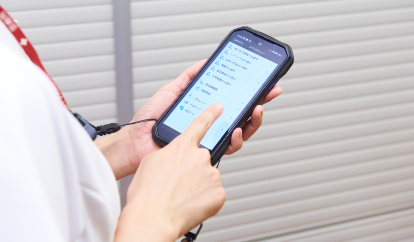 看護師が高耐久スマートフォン「DuraForce EX」を操作する様子