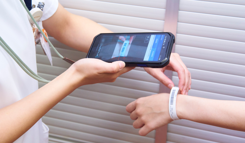 看護師がスマートフォンで患者のバーコードを読み取っている様子