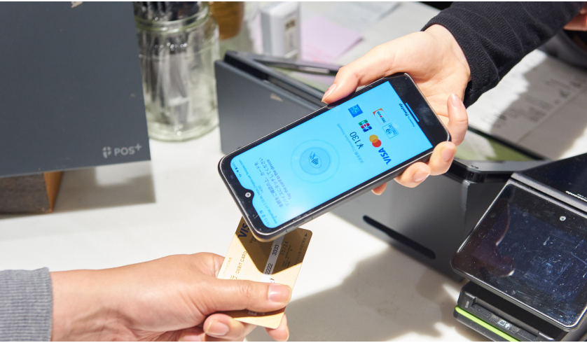 スマホPOSにクレジットカードをかざしている様子