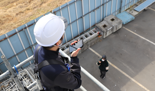 足場3階と地上で通話している様子