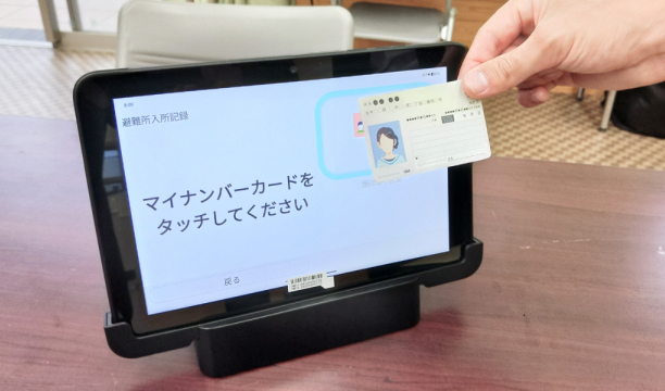 マイナンバーカードをタブレットにかざしている様子